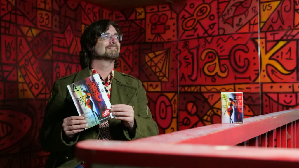 René van Densen met zijn dichtbundel en kaartset "Als Een Ravijn Een Richting Is"