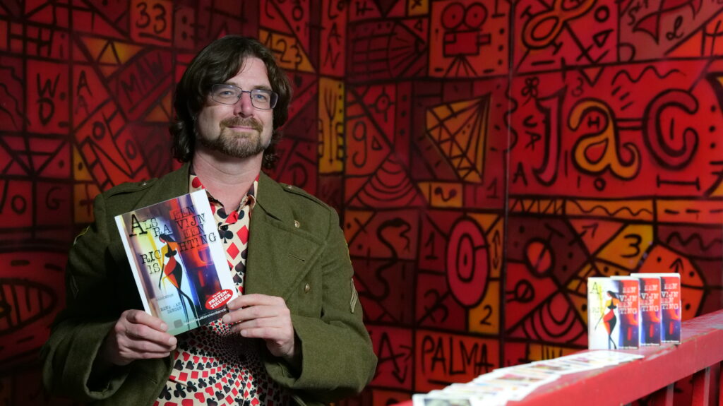 René van Densen met zijn dichtbundel en kaartset "Als Een Ravijn Een Richting Is"