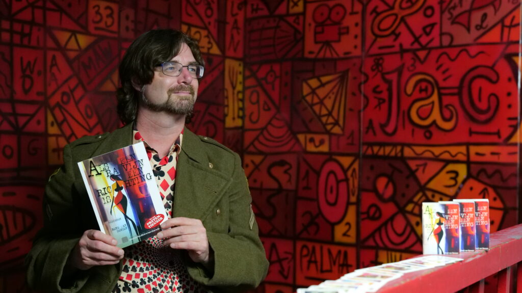 René van Densen met zijn dichtbundel en kaartset "Als Een Ravijn Een Richting Is"